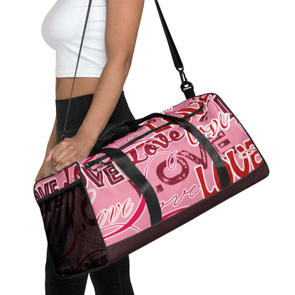 Frau trägt pinke Sporttasche mit Love-Schriftzug, schwarzer Schultergurt, modernes Design