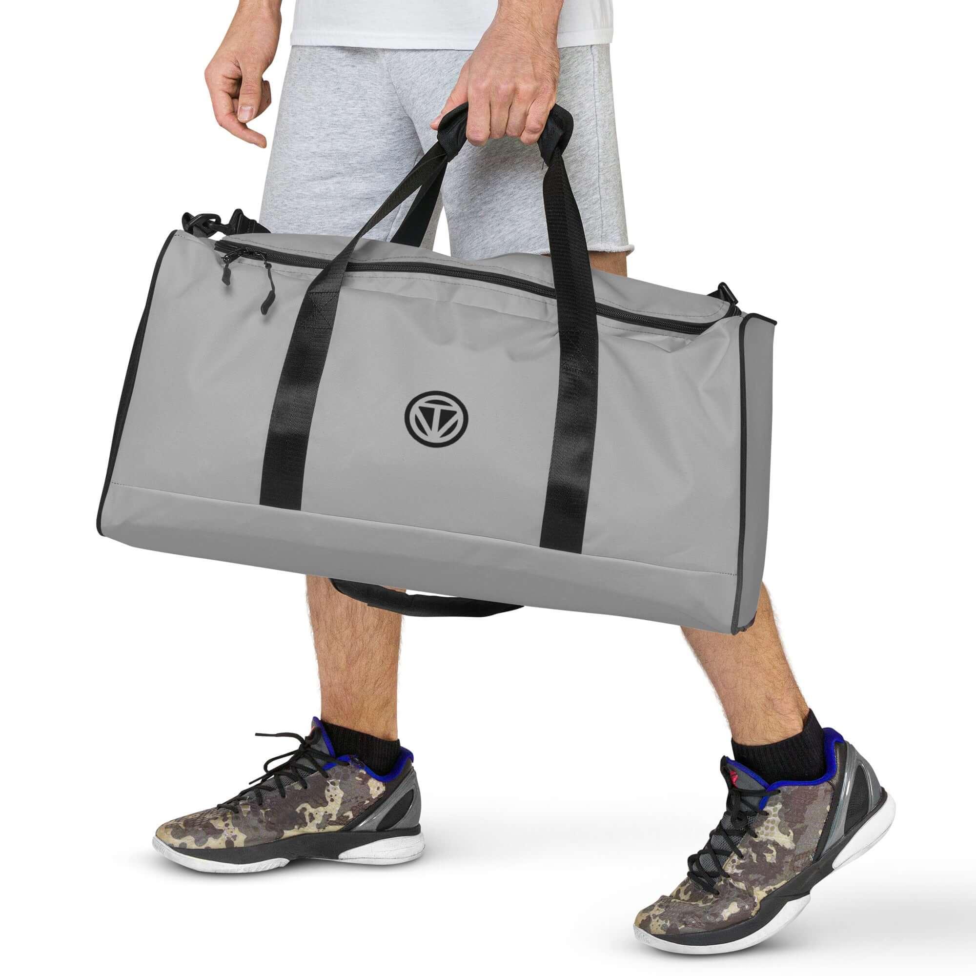 Graue Sporttasche mit schwarzen Trägern, Fitness Logo, getragen von Mann in Shorts