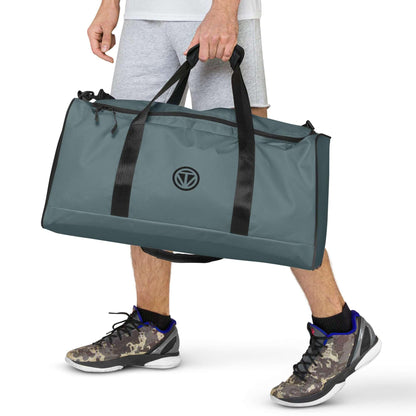 Graue Sporttasche mit schwarzen Henkeln, getragen von Person in Shorts und Sportschuhen