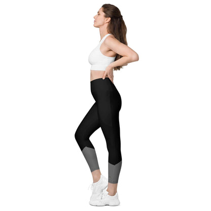 Frau in schwarzer Leggings mit Taschen und weißem Sporttop, seitliche Ansicht, weißer Hintergrund