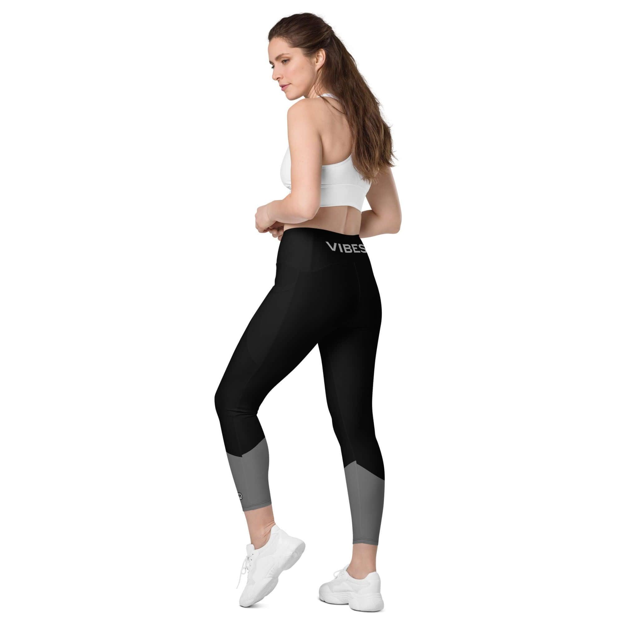 Frau in schwarzer Leggings mit Taschen und weißem Sport-BH vor weißem Hintergrund