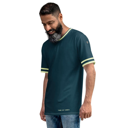 Mann trägt dunkelgrünes T-Shirt mit gelben Streifen, Aufschrift TIME OF VIBES, Jeans, Studioaufnahme.