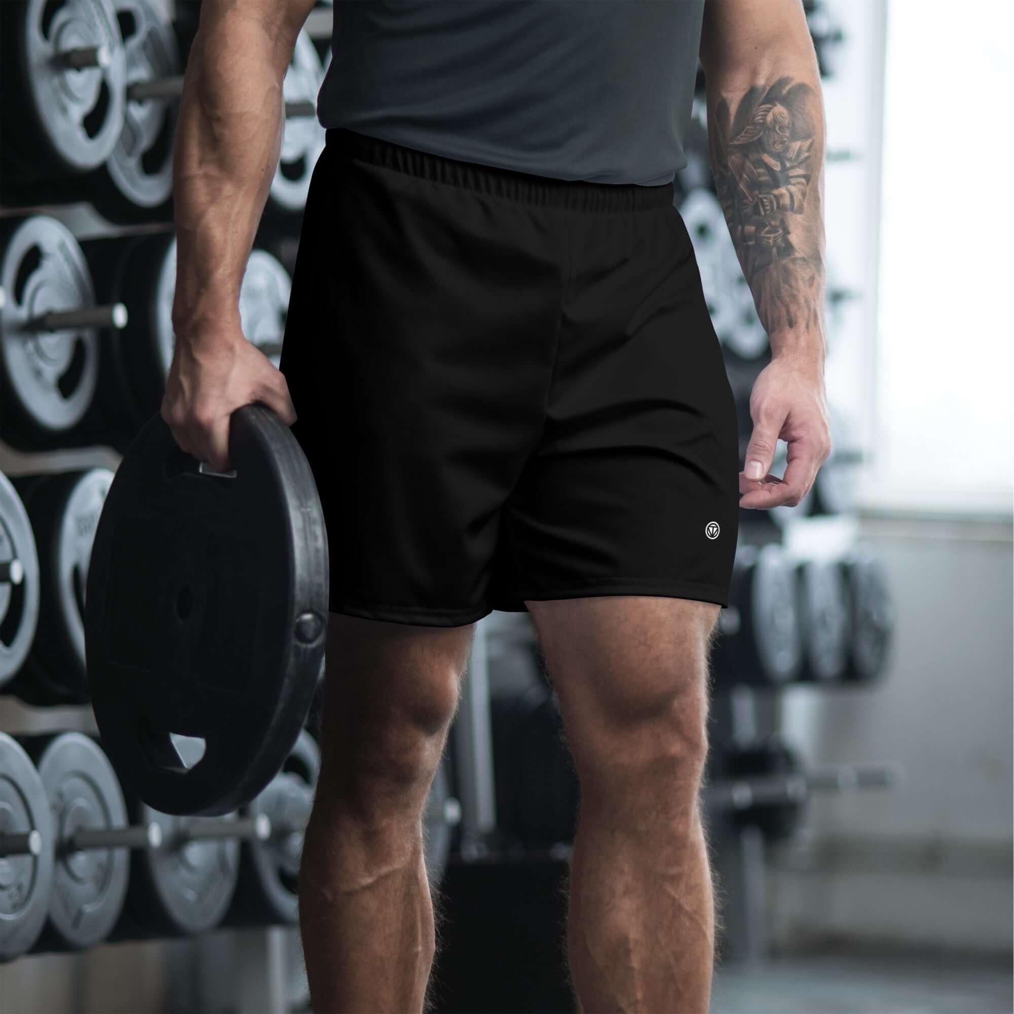 Mann in schwarzen Fitness-Shorts im Fitnessstudio mit Hantel, Sportbekleidung Herren