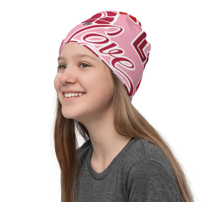 Mädchen mit rosa Allover-Print Beanie mit Love-Schriftzug, lächelnd, seitliche Ansicht.