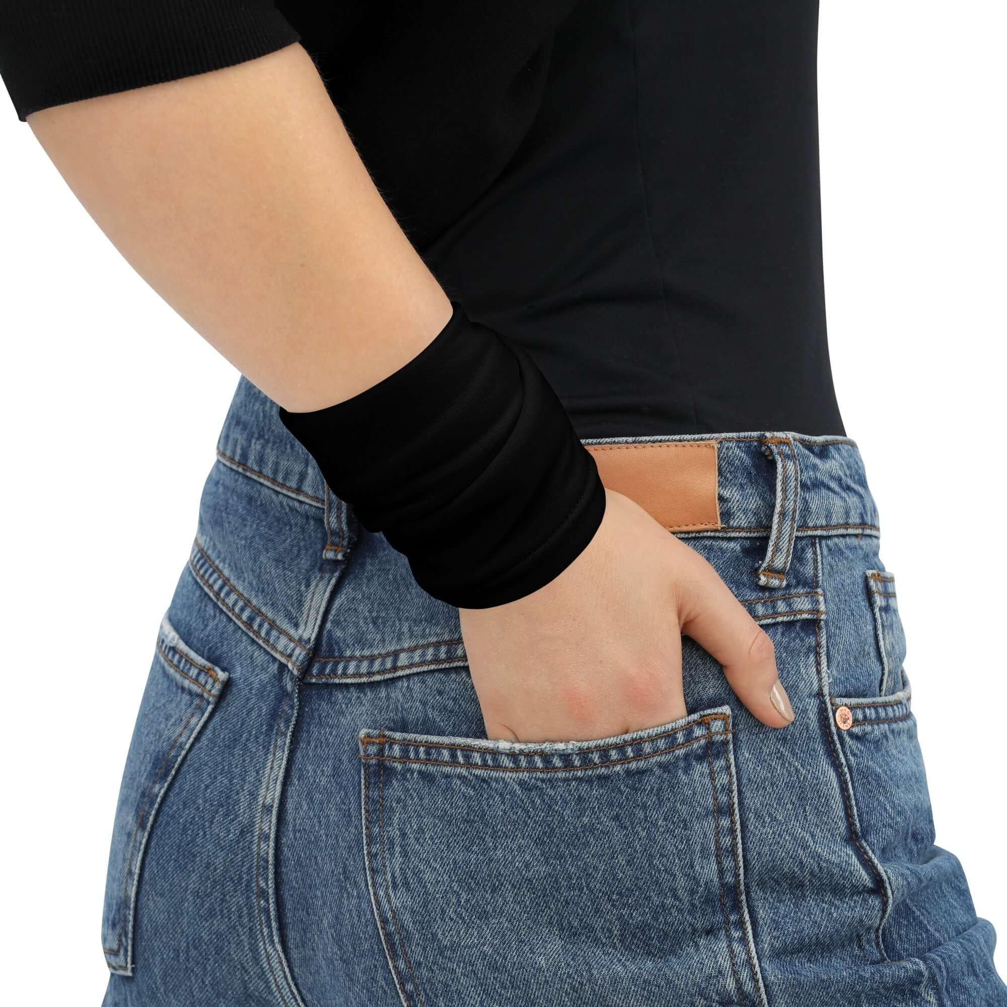 Frau trägt schwarzes Multifunktionstuch am Handgelenk und blaue Jeans