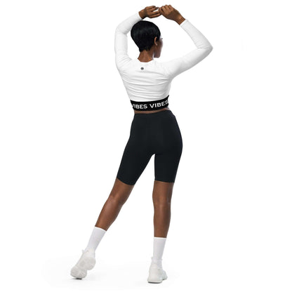 Frau mit weißem Longsleeve Crop Top und schwarzer Radlerhose, Fitness Mode, Rückansicht