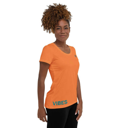 Frau trägt orange Damen Sport T-Shirt mit Vibes Schriftzug, isolierter Hintergrund