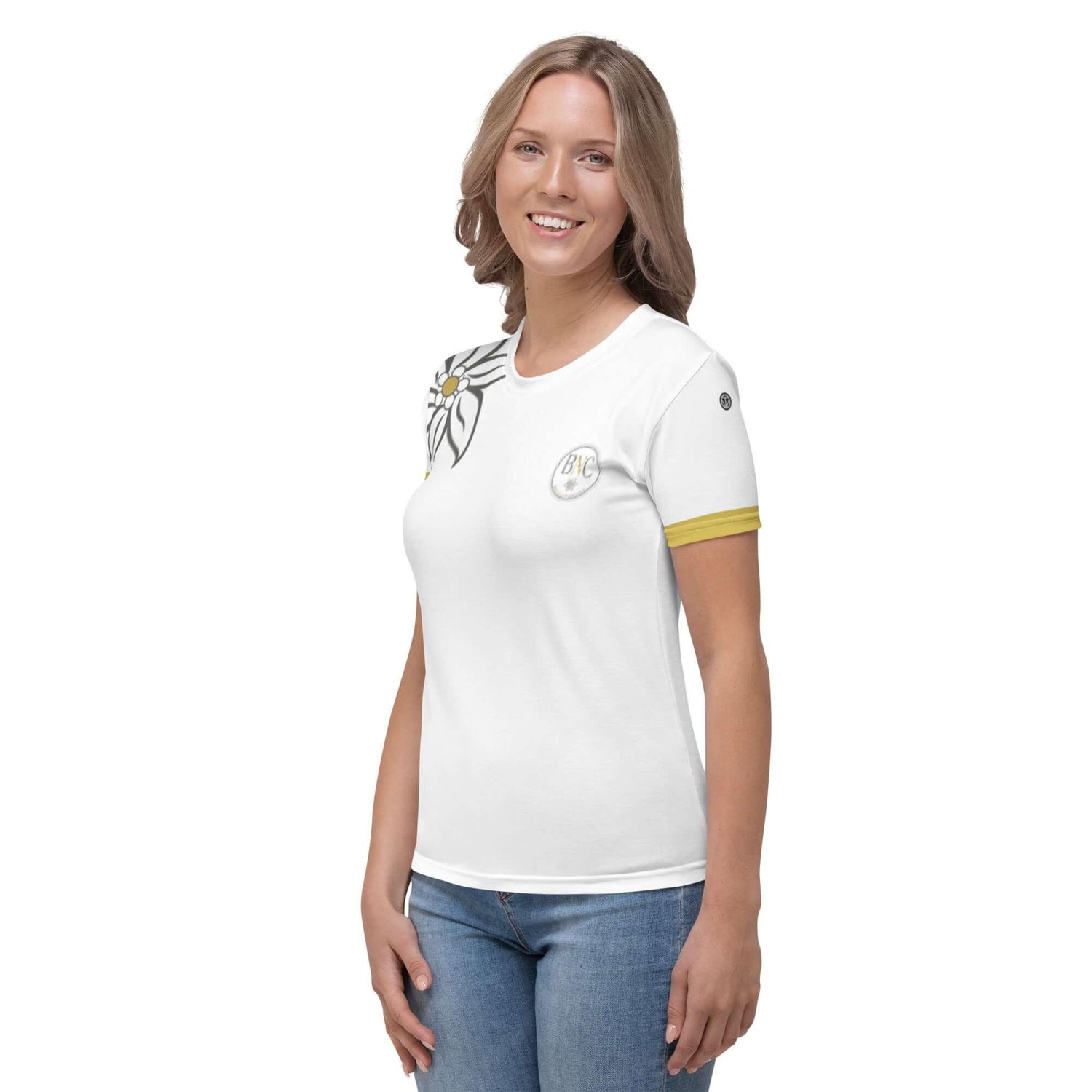 Frau trägt weißes Damen T-Shirt mit Blumenmuster und gelbem Ärmelsaum vor weißem Hintergrund.