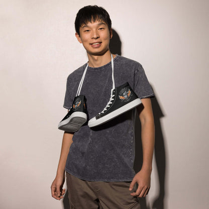 Junger Mann mit schwarzen High-Top-Sneakern und grafischem Muster, lässiger Look, Mode