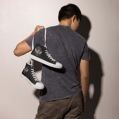 Mann mit schwarzen High-Top-Canvas-Sneakern mit Print-Motiv über der Schulter
