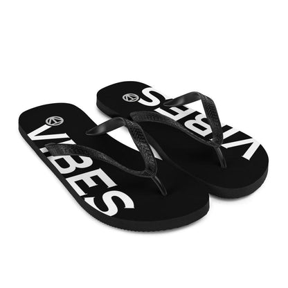 Schwarze Flip Flops mit weißem VIBES-Schriftzug und schwarzen Riemen auf weißem Hintergrund.