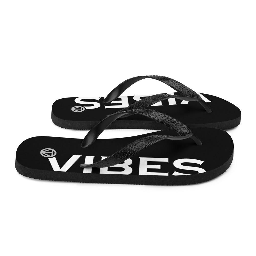 Schwarze Flip-Flops mit weißem VIBES Schriftzug auf der Sohle, Modetrend Sommer Sandalen