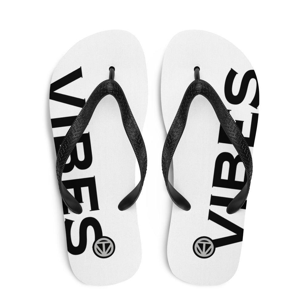 Weiße Flip-Flops mit schwarzem VIBES-Aufdruck und schwarzen Riemen, Produktfoto